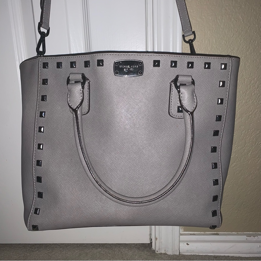 Michael Kors gray studded tote purse with cross body strap.